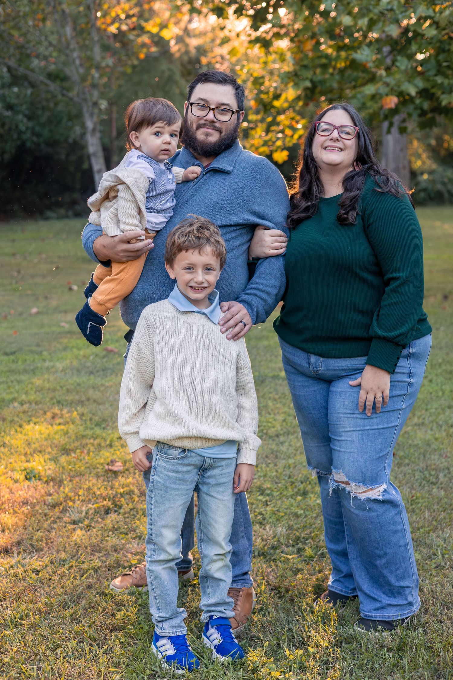 Mom, dad, toddler boy, and young son pose for a family photo.