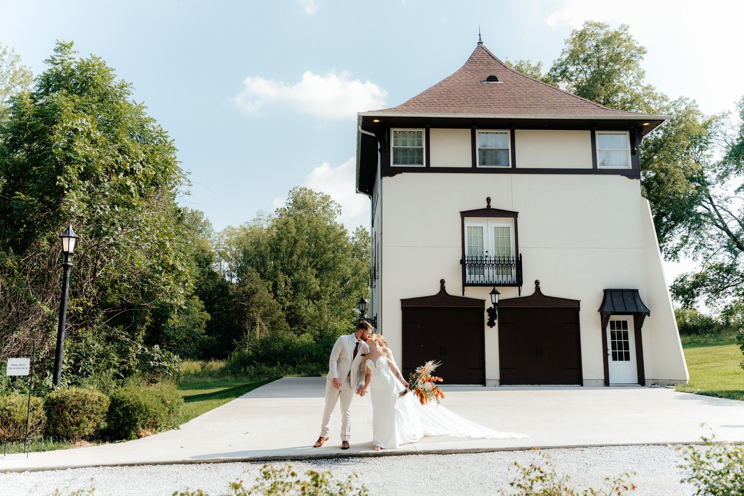 Wedding couple standing in front of a unique black and white architectural building on a sunny day.
