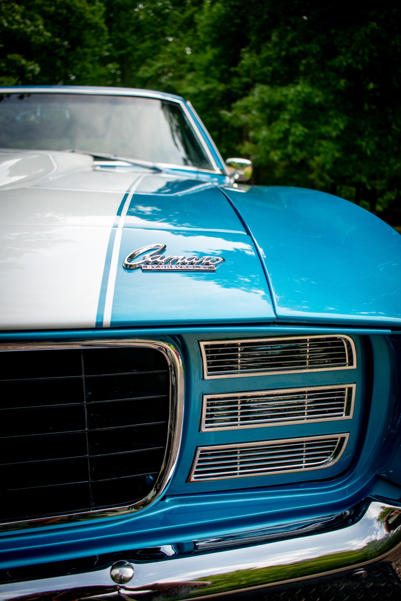 Front grille and hood detail of blue and white Camaro SS showing classic styling.