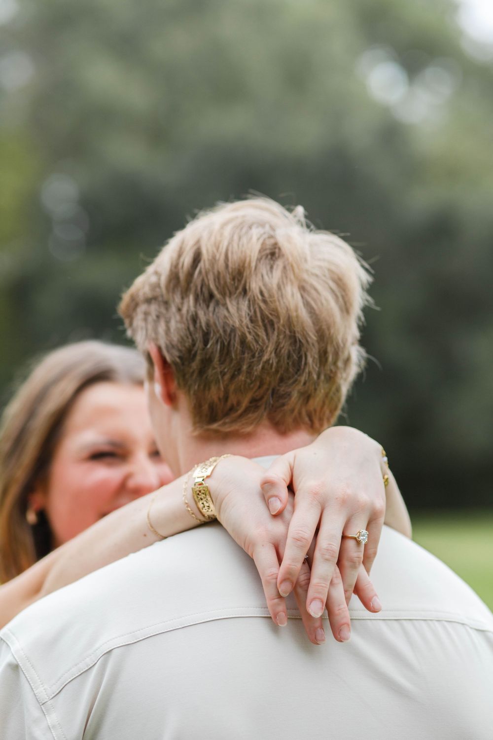 Close-up of an embrace showing a new engagement ring.