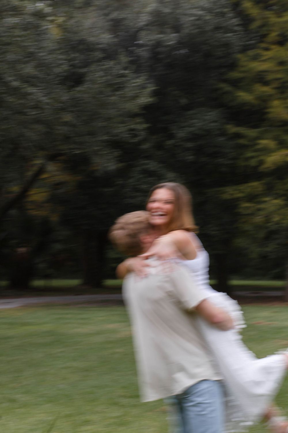 Blurred motion shot of joyful couple embracing in a park.