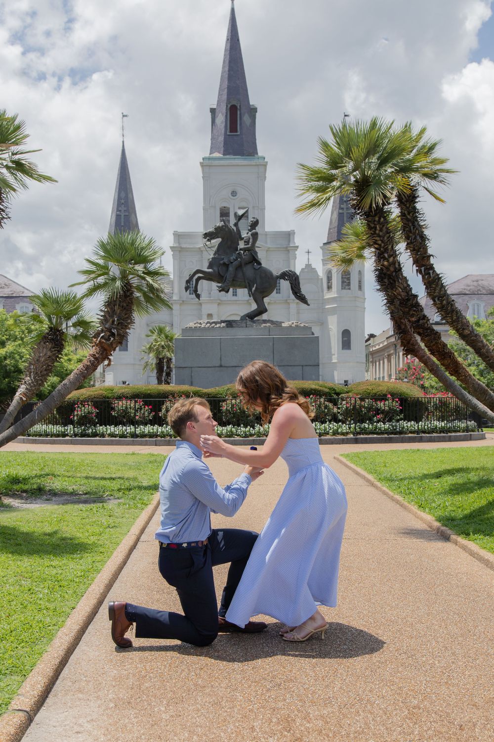 A couple sharing a romantic moment on a path near Jackson Square with St. Louis Cathedral in New Orleans.