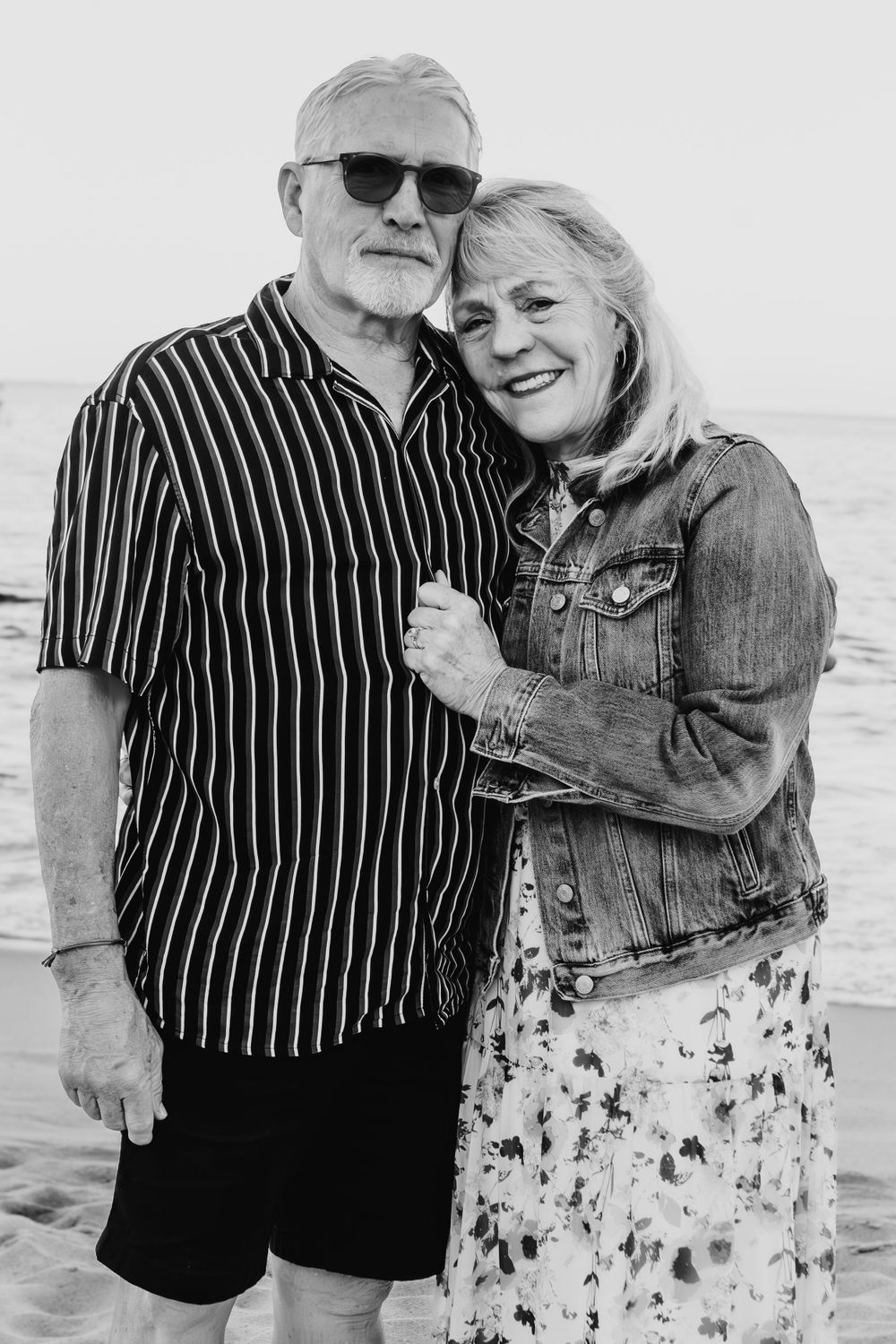 A mature couple sharing a happy moment on the beach in black and white.