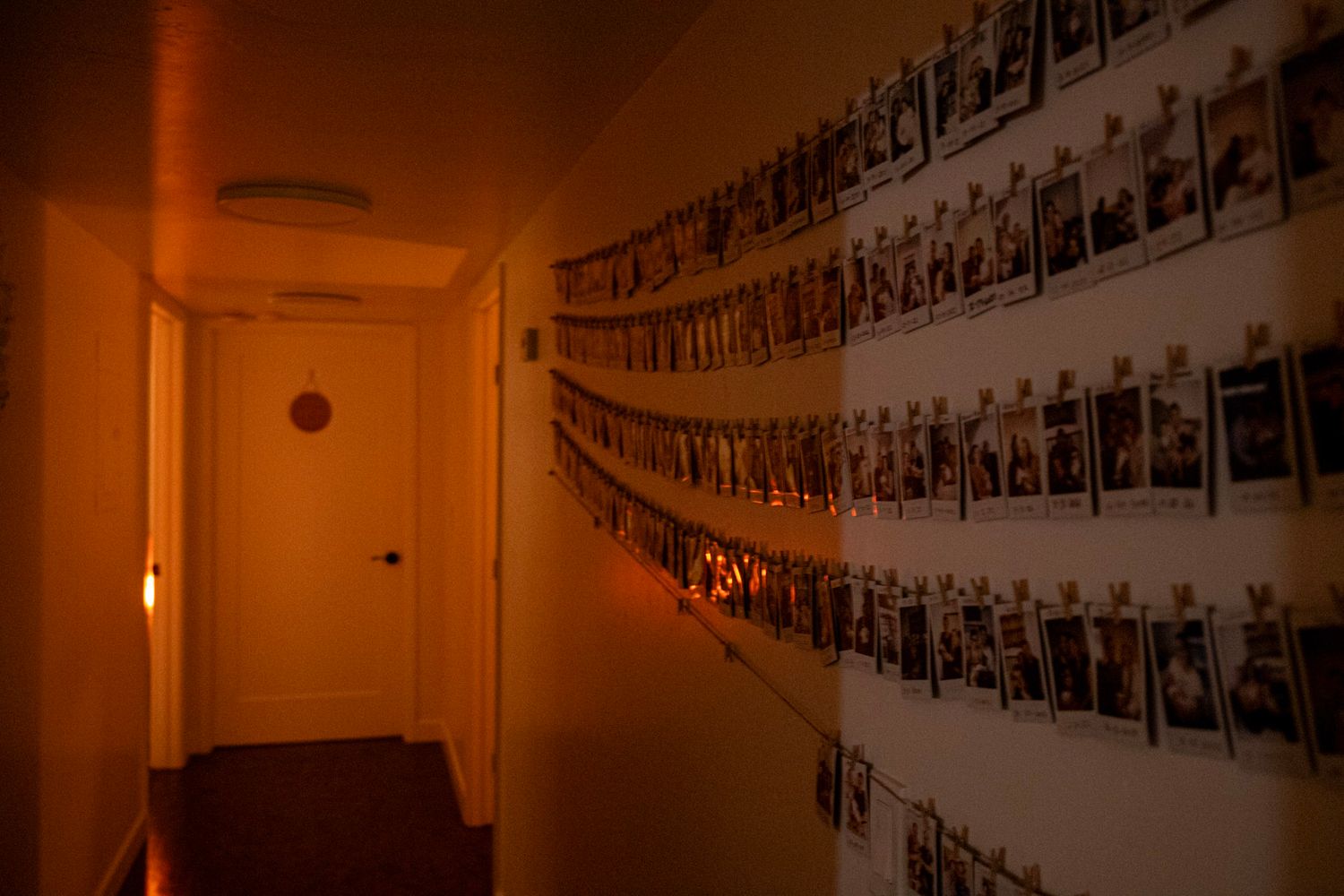 A dimly lit hallway with walls covered in photographs creating a gallery-like display. While in a birth center.