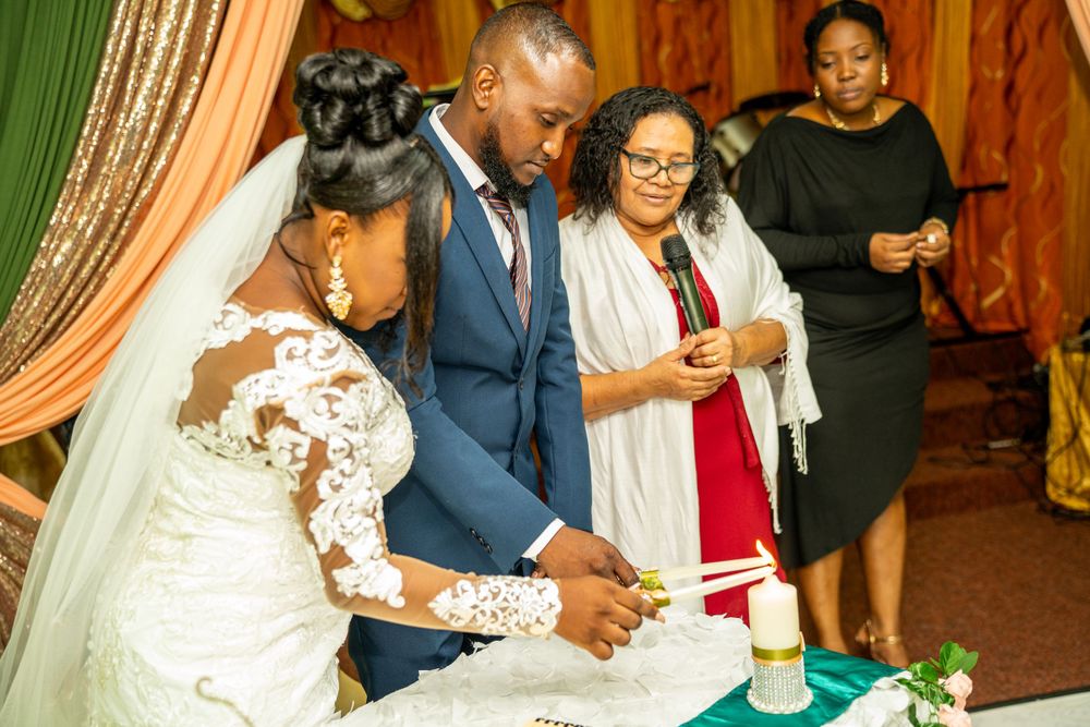 A wedding ceremony signing moment with guests watching in a room decorated with colorful drapes.
