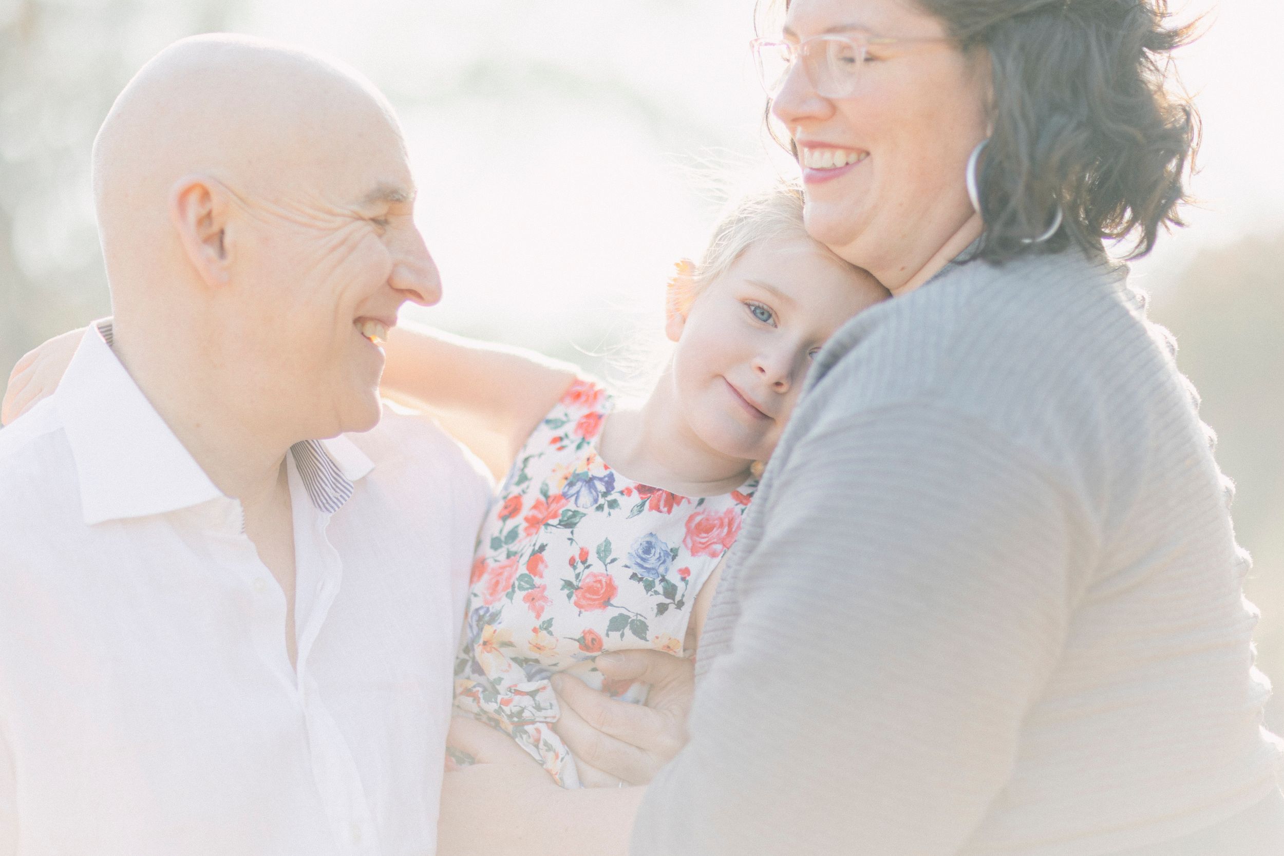 A dreamy outdoor family portrait with soft lighting and tender embraces.