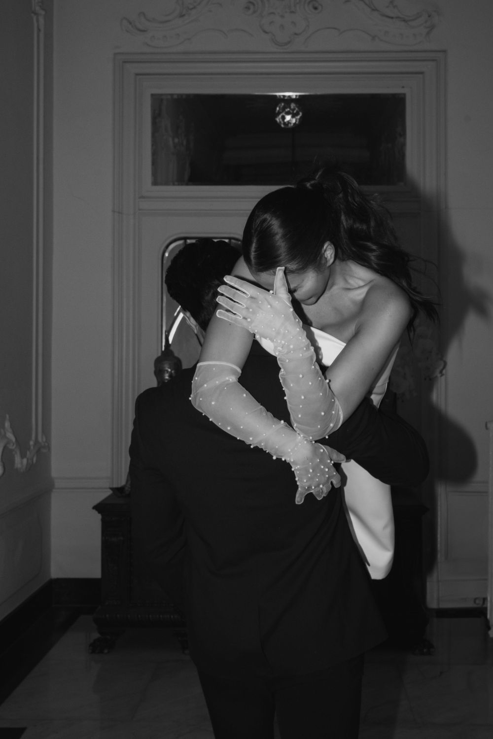 An intimate black and white moment captured of a couple dancing in formal wear.