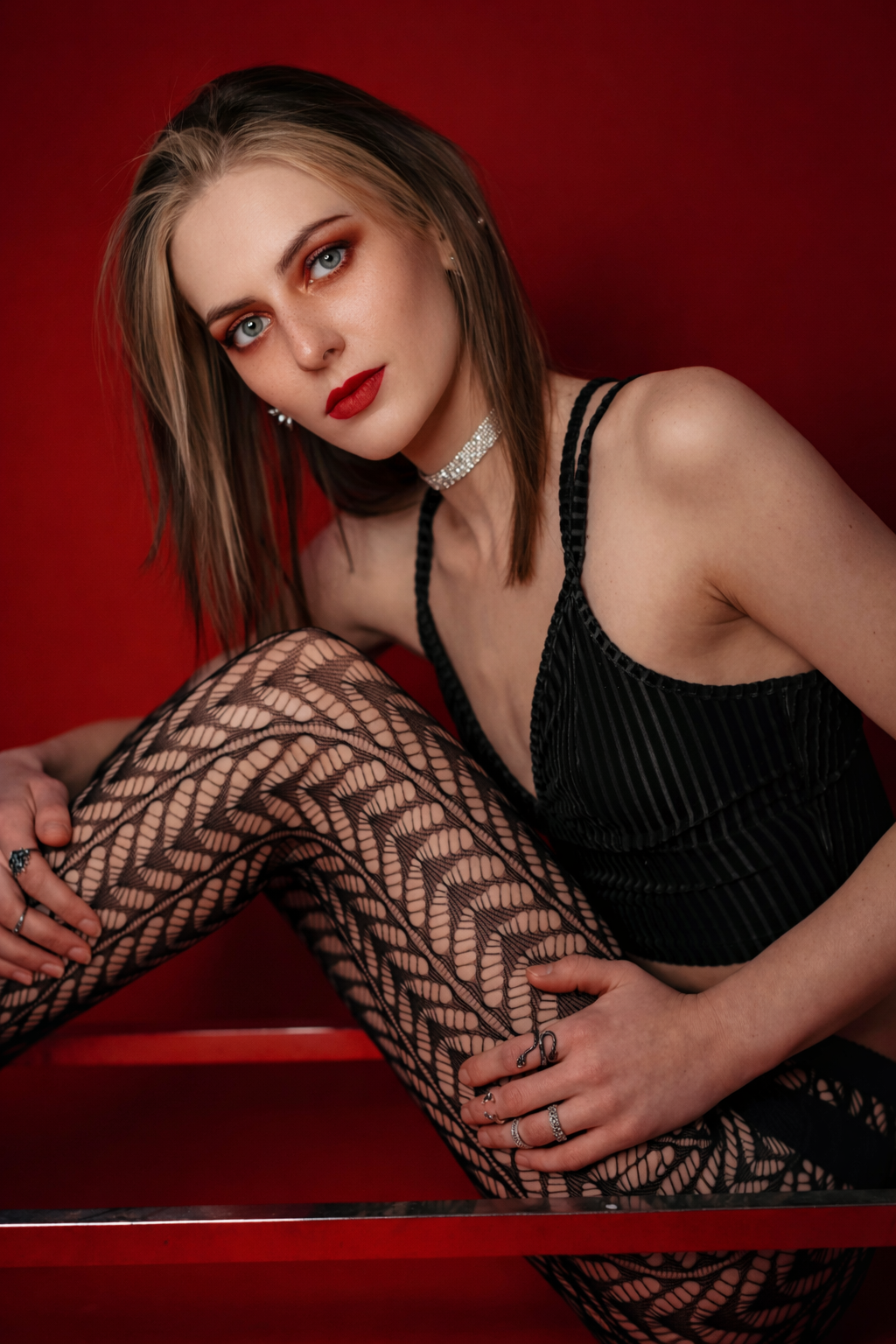 A glamour portrait series with dark red backdrop showing artistic poses in patterned stockings and black attire.