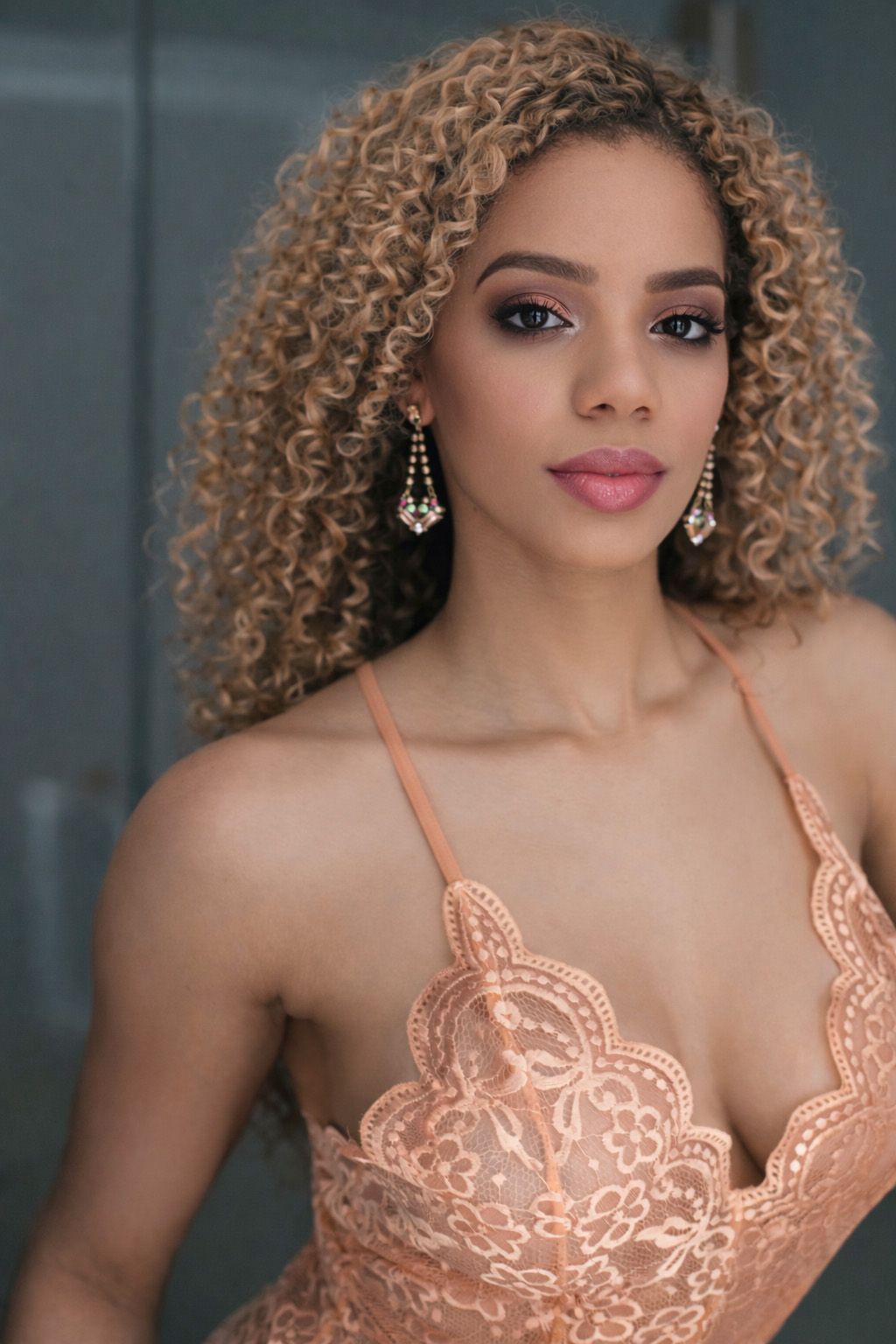 A series of glamour shots showing curly honey-blonde hair and a peach-colored lace dress against a gray background.