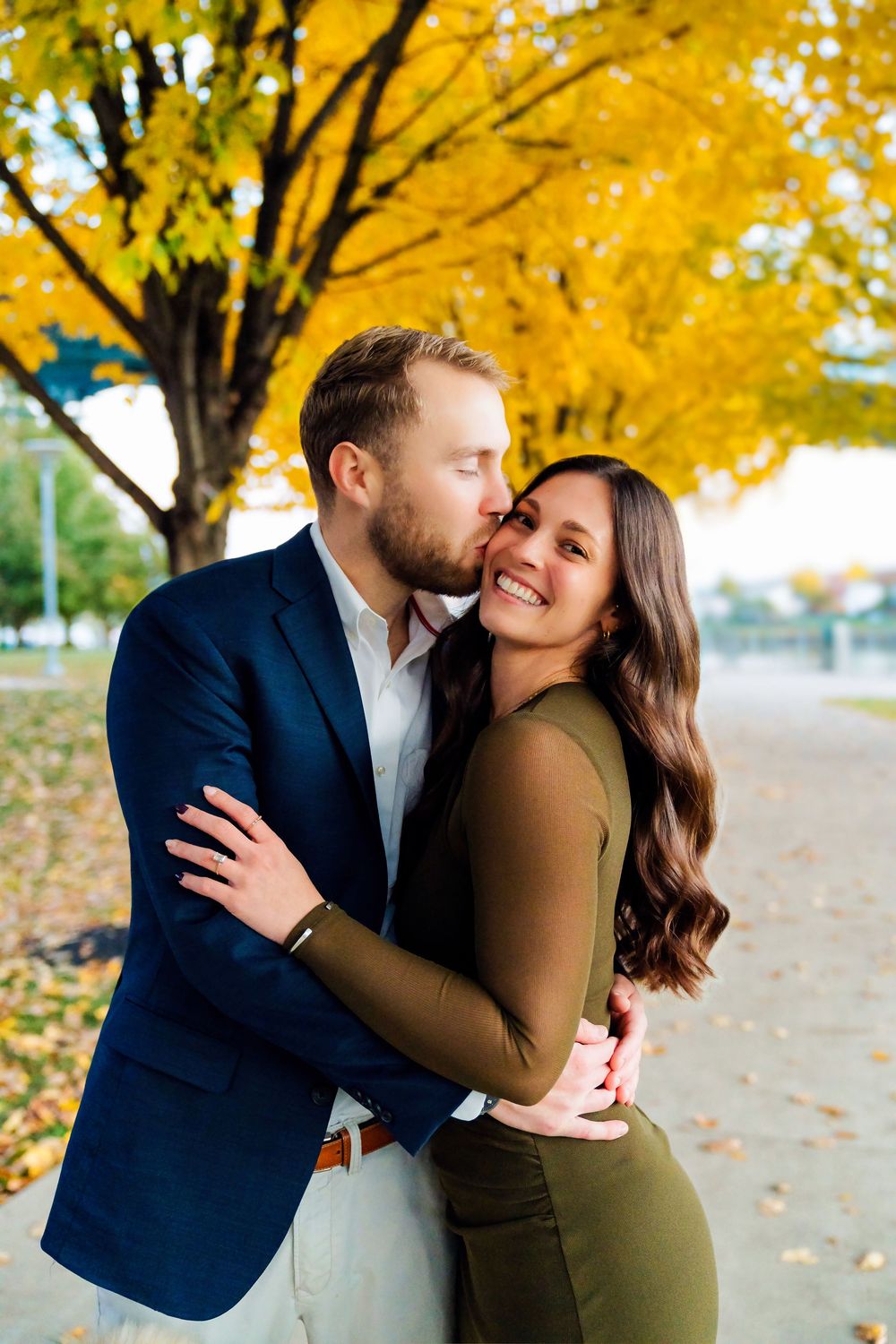 Liz and Chris's Engagement Downtown Cincinnati at Smale Park kissing with fall leaves: Cincinnati Wedding Photographer