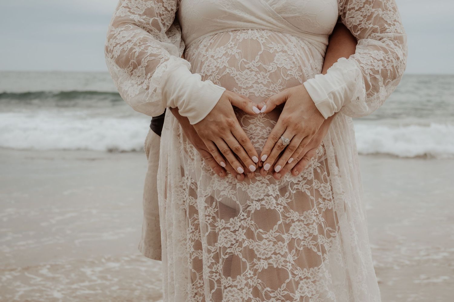 Delicate lace details on a cream colored maternity dress shown in close-up shots at a central coast maternity photoshoot.
