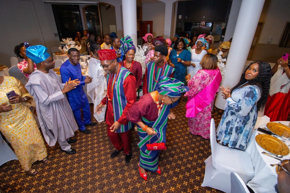 A large group of people gathered in a carpeted room for what appears to be a cultural or social event.