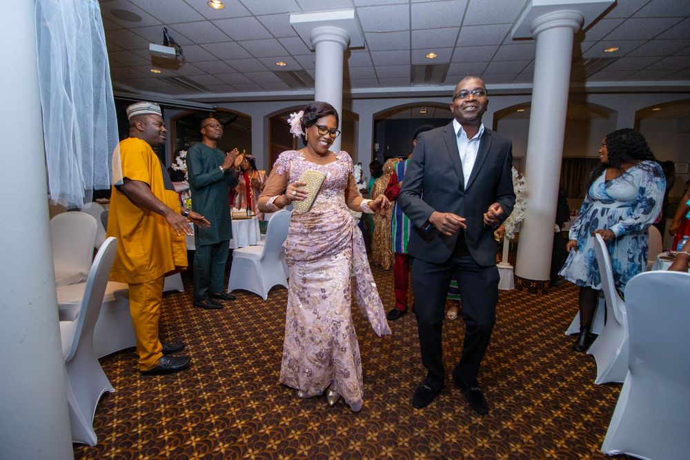 Wedding guests dance and celebrate together on a carpeted ballroom floor at an indoor reception venue.