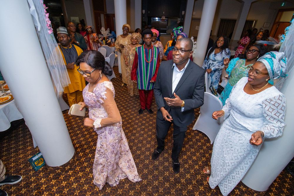 Wedding guests dance and celebrate on a checkered ballroom floor at an elegant reception venue.