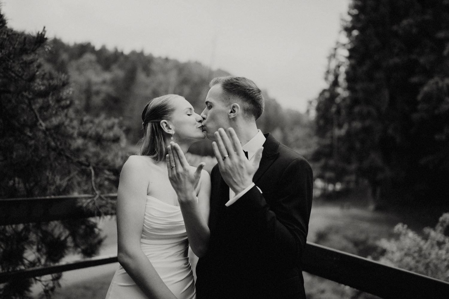 Intimate black and white portrait of a couple sharing a romantic moment outdoors.