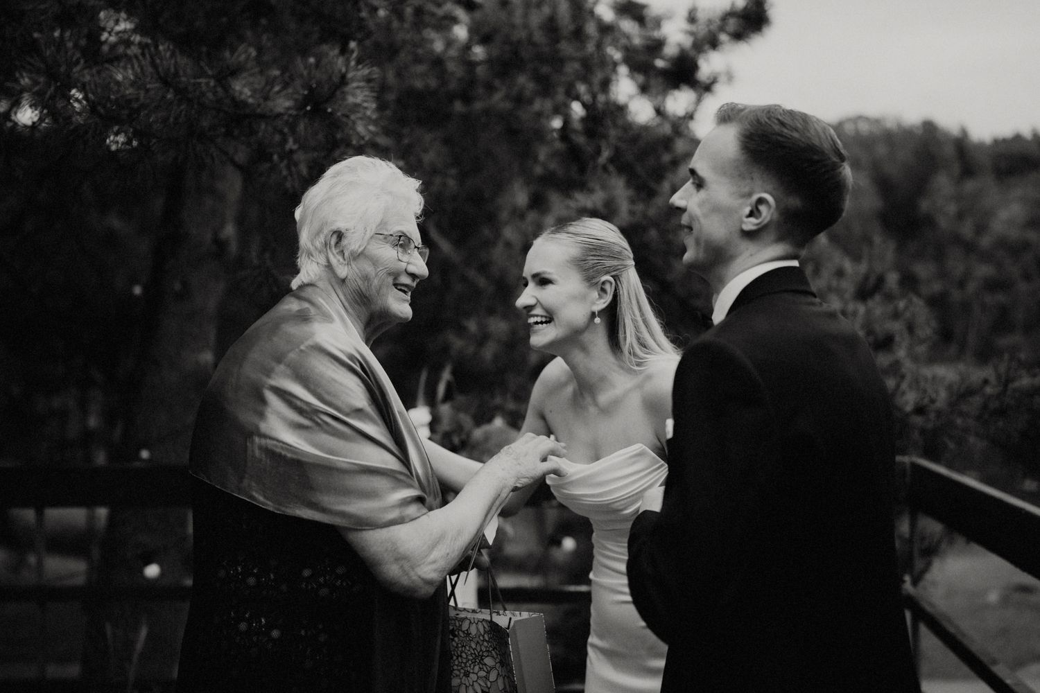 Candid black and white shots of wedding celebration moments in a forest setting.
