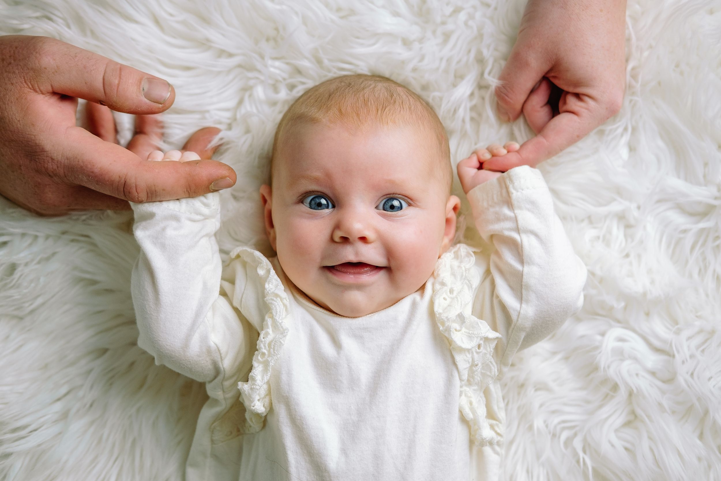 Four-month-old baby lying on a flokati rug during a studio photoshoot