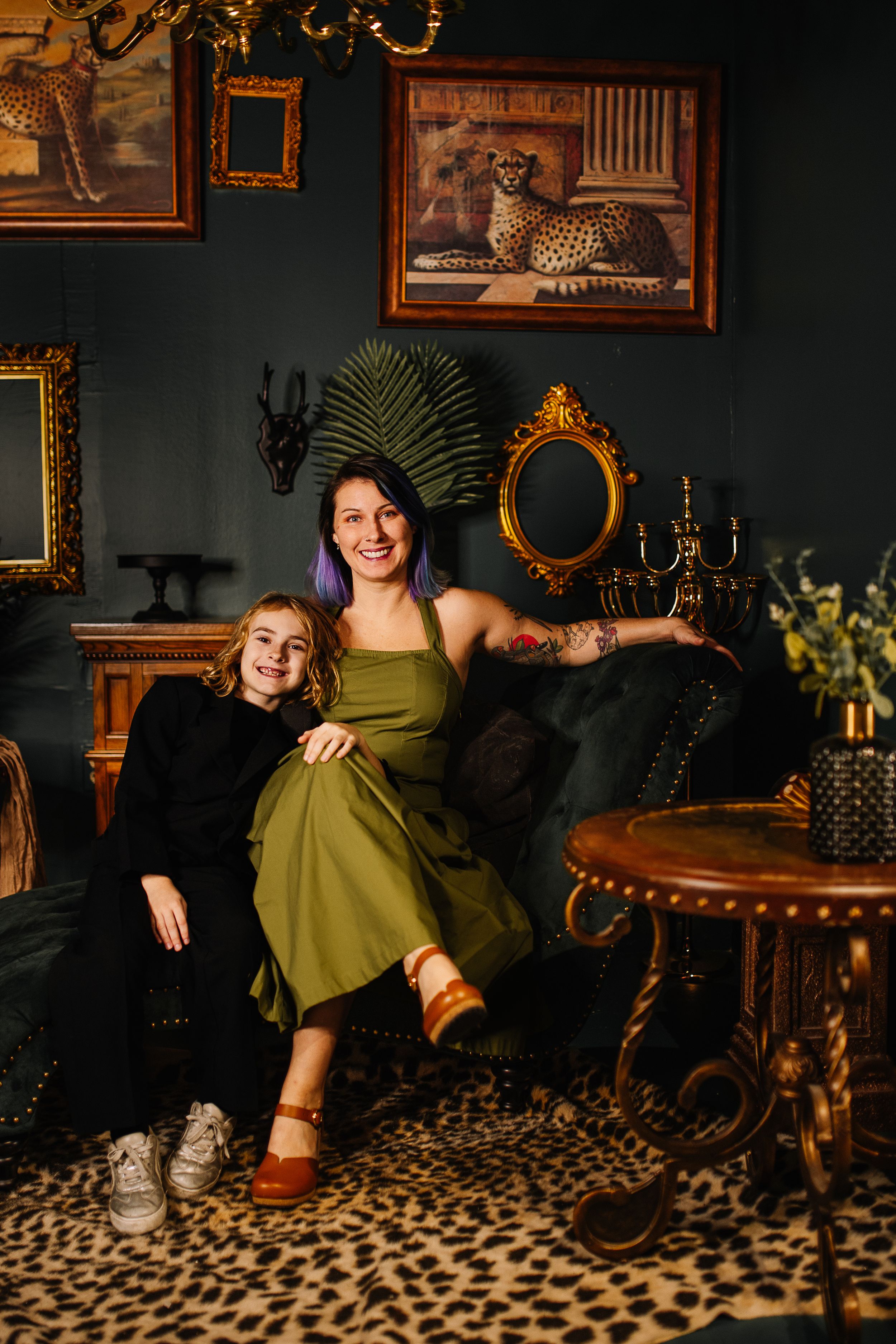 Vintage-inspired interior with leopard print rug, ornate gold frames, and dark green walls creates moody retro ambiance.