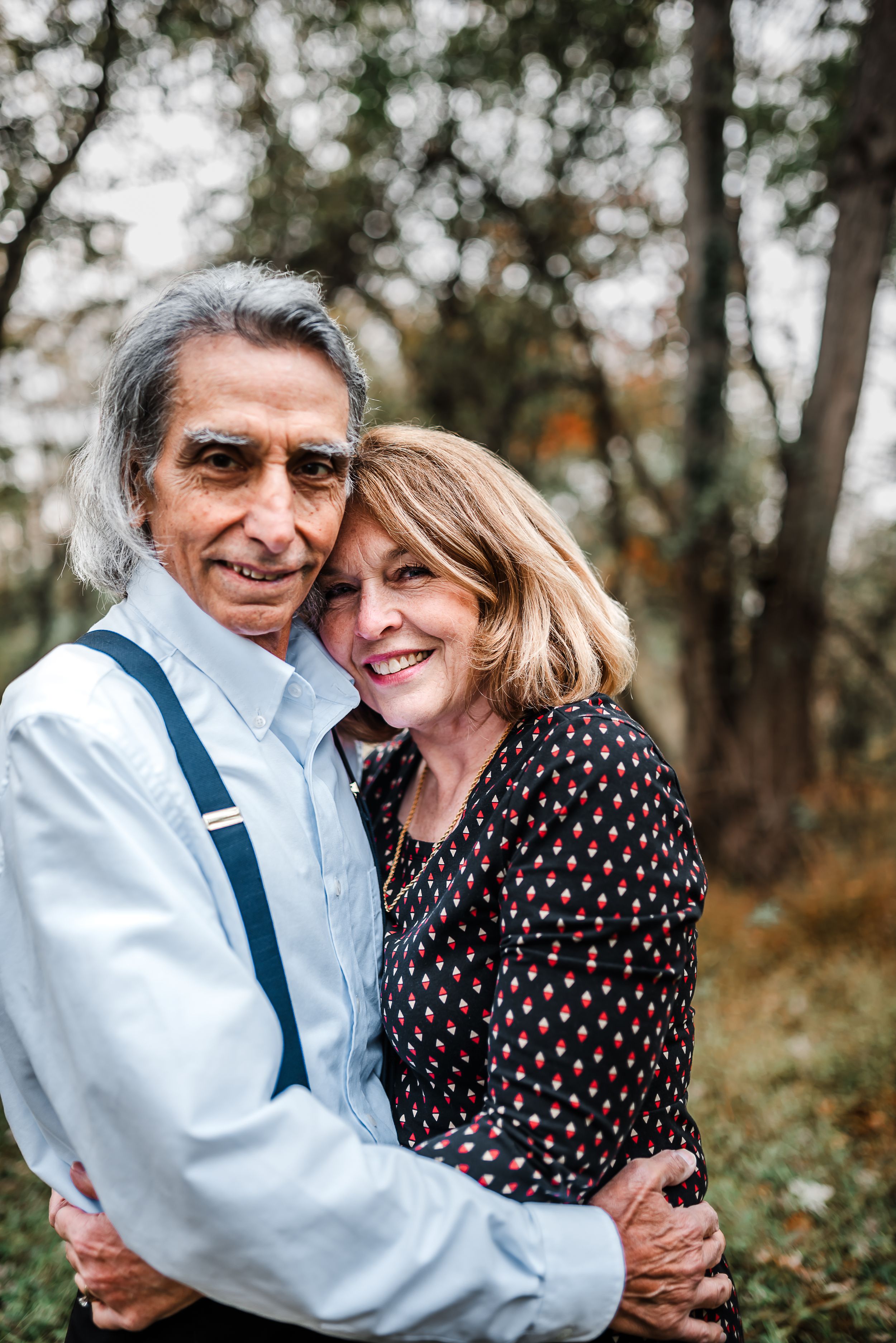 Romantic outdoor photo series showing a couple embracing and laughing together in a natural wooded setting.