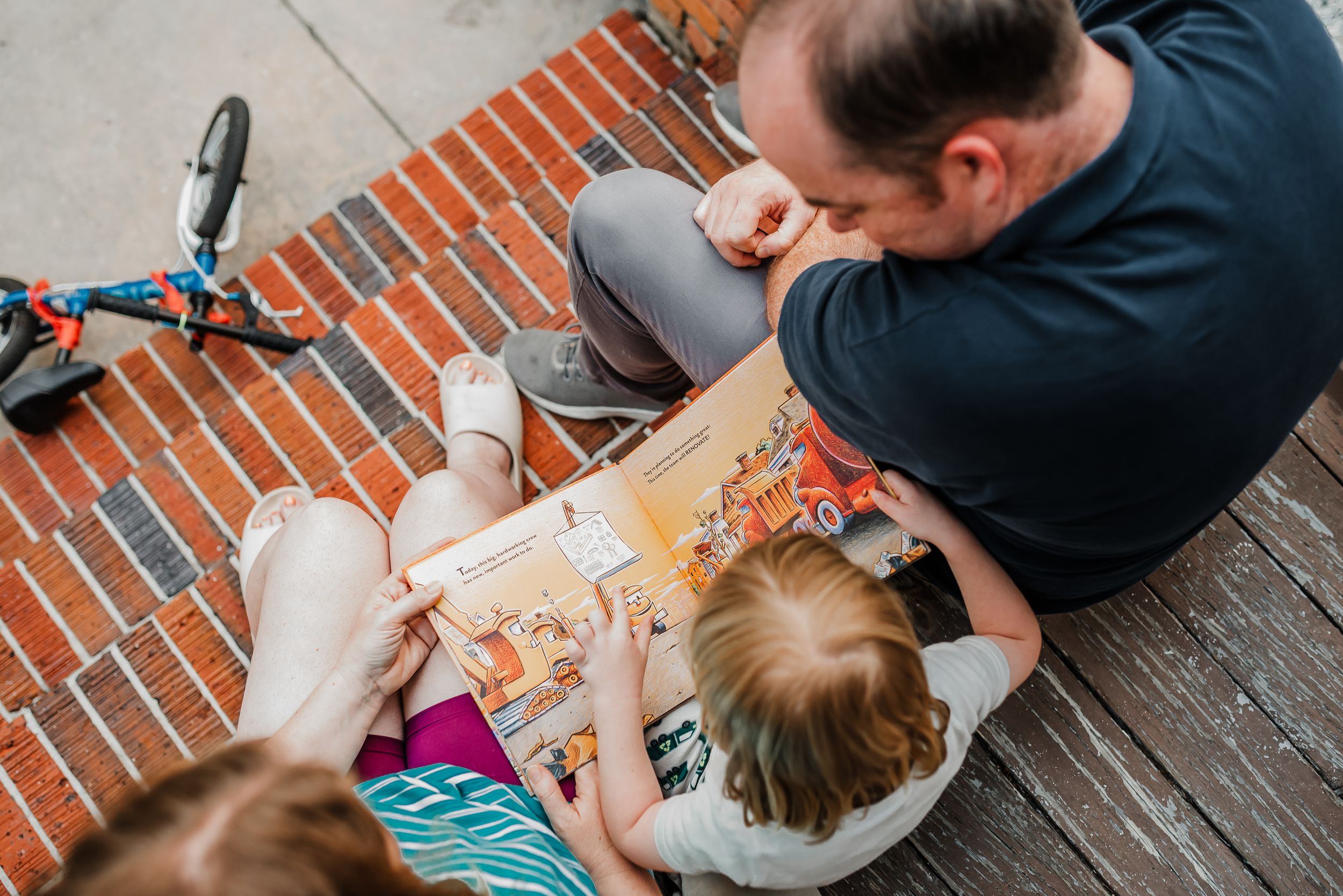 People sitting on a wooden deck playing a board game together on a sunny afternoon.