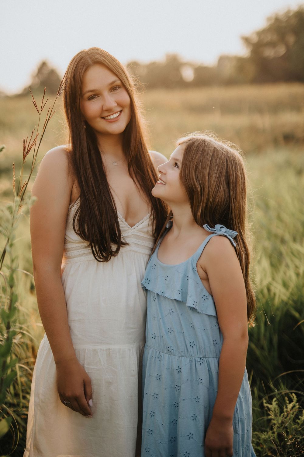 A sweet moment between two people in a sunlit field during golden hour.