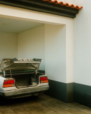 Open car trunk parked in a garage with white walls and dark baseboards.