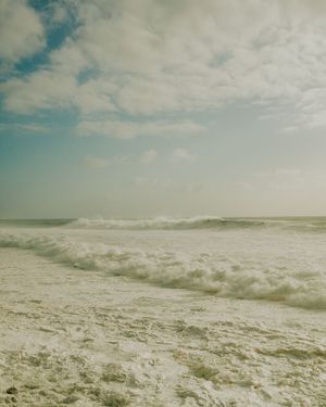 A panoramic sequence of crashing ocean waves and white foam against a cloudy sky shows the raw power of the sea.
