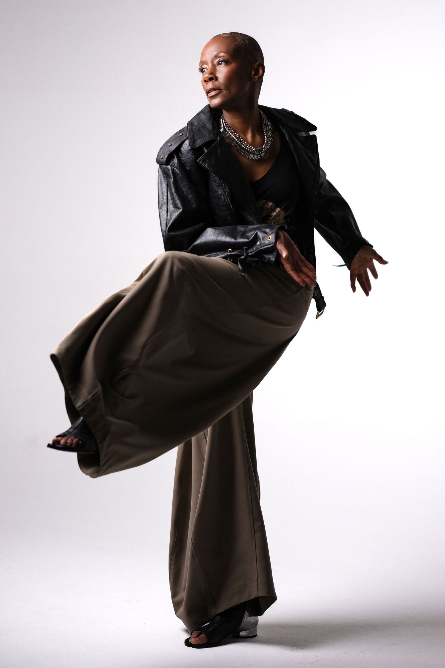 Dynamic fashion poses showing movement in oversized jacket and flowing pants.