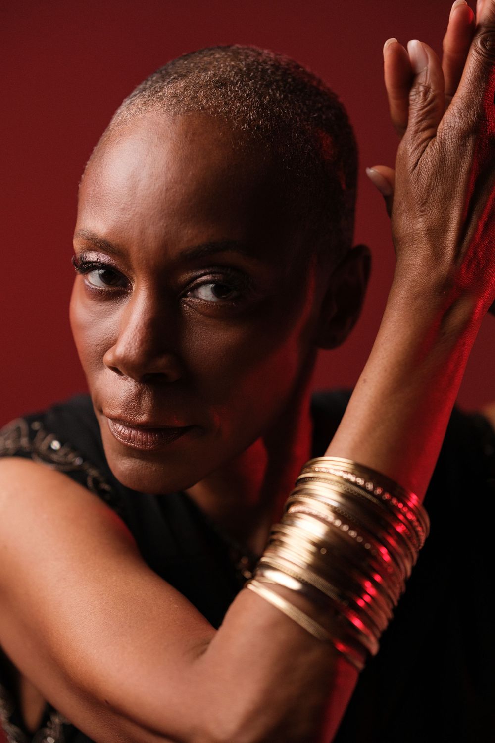 Artistic close-up shots highlighting gold bangles and dramatic expressions in red lighting.