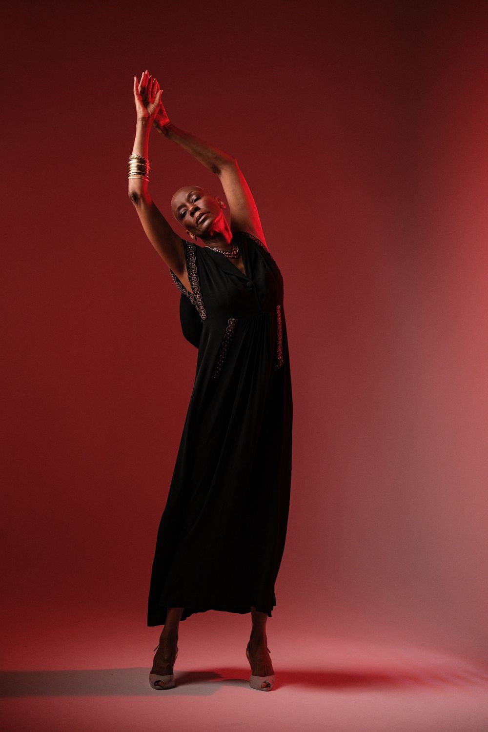 Expressive dance poses captured in silhouette against deep red studio lighting.