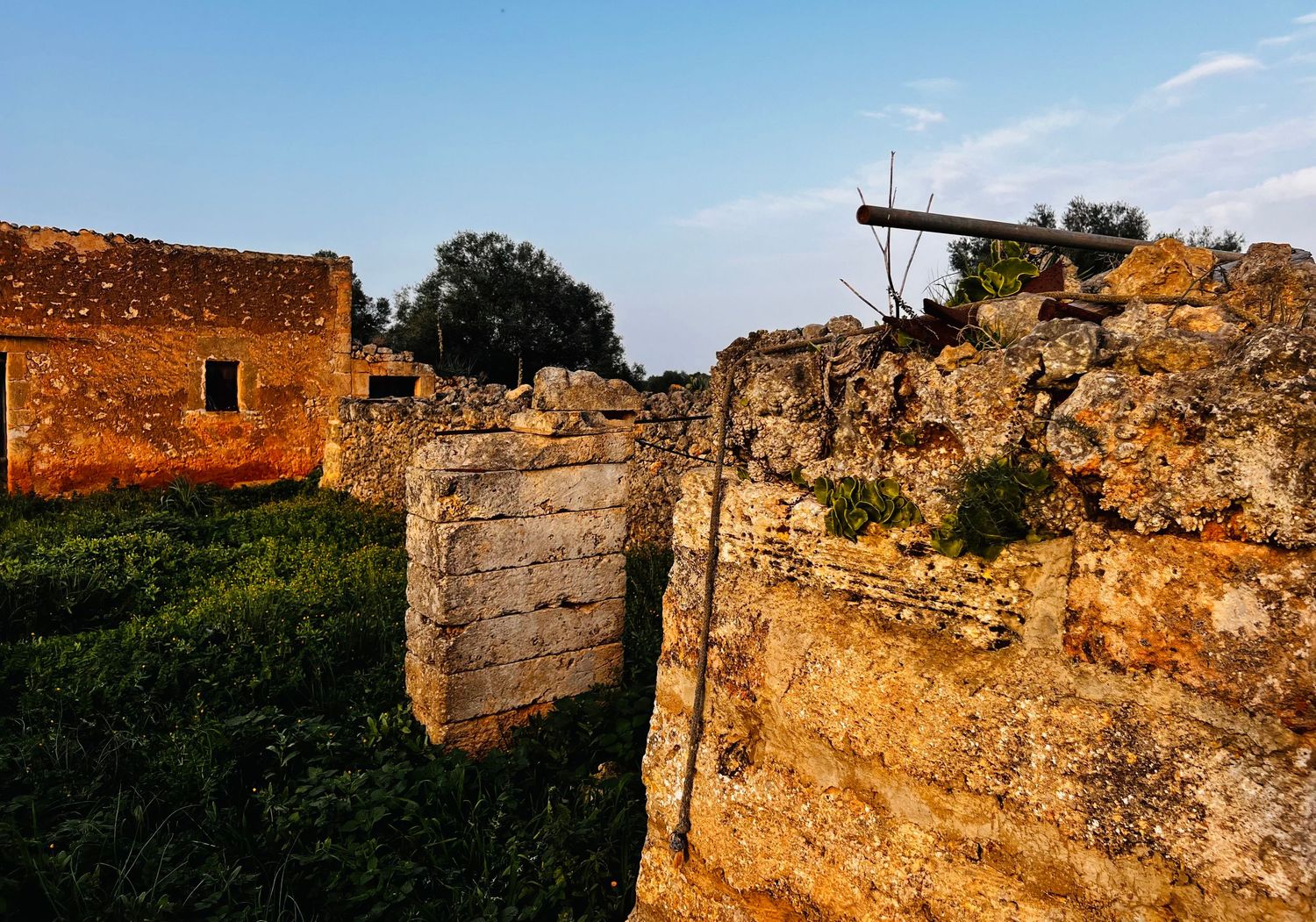 Ancient stone fortress ruins stand against blue sky in panoramic view of historic Mediterranean architecture.