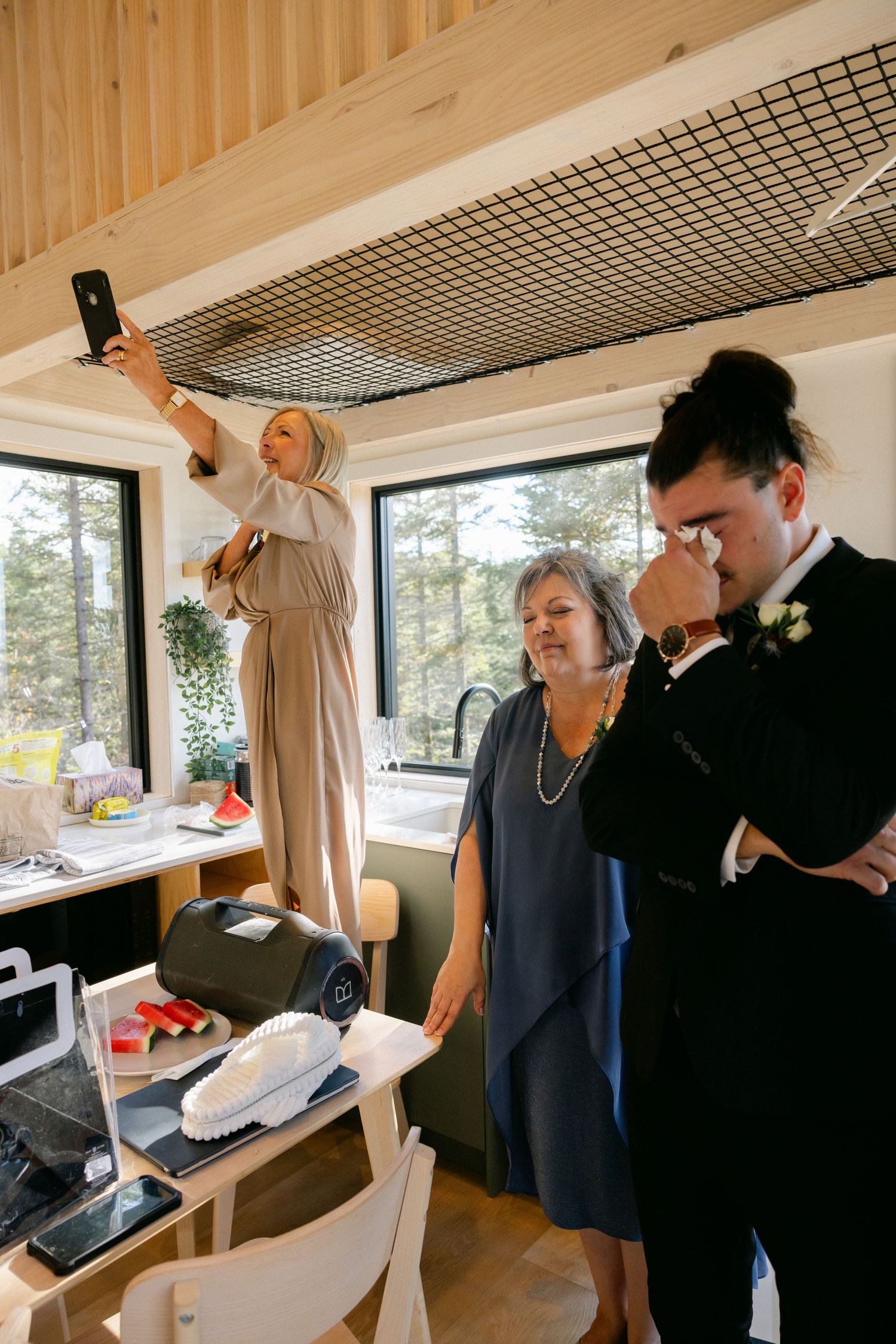 Two people inspect storage solutions and organization systems inside a modern tiny home interior.