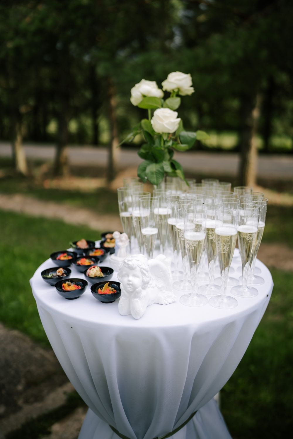 Elegant cocktail reception setup with champagne glasses and appetizers on white tablecloth.