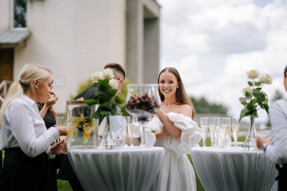 Wedding reception table settings with glassware and decorations outdoors.