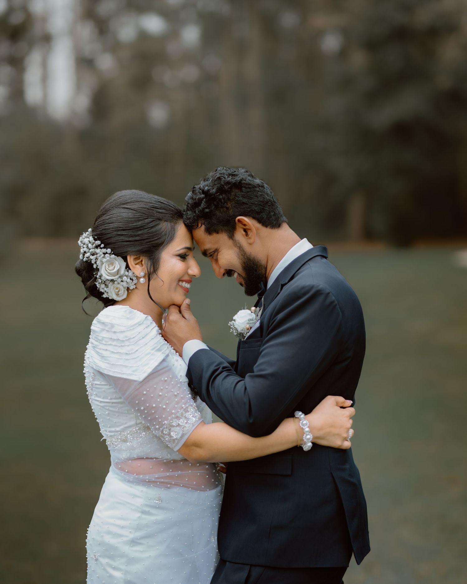 A couple shares an intimate embrace during their wedding photoshoot outdoors.