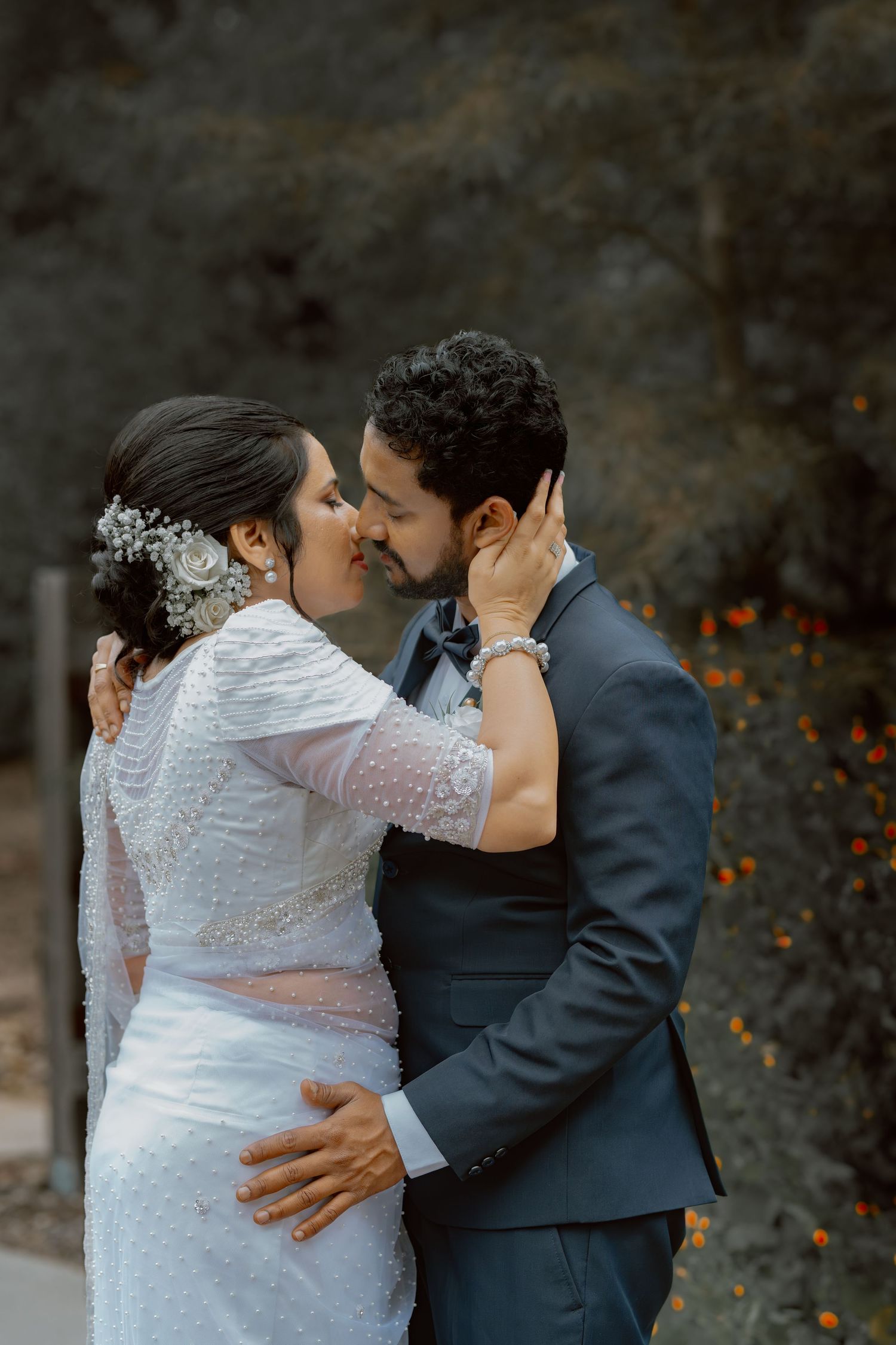 A tender moment between newlyweds captured against a dark textured background.