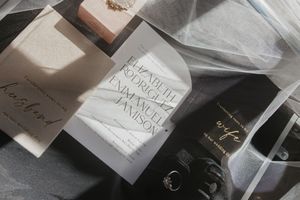 Wedding stationery and invitations arranged artistically with handwritten text on white paper.