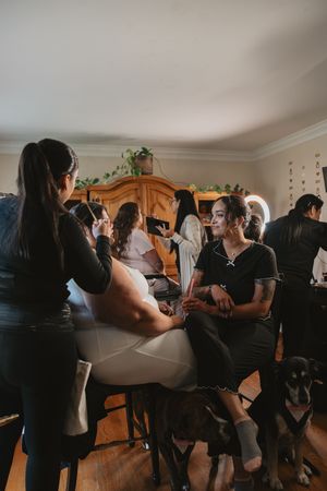 A group gathers in a living room for an intimate celebration with warm lighting and wooden furniture.
