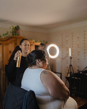 Two people share an intimate moment during a wedding ceremony in a warmly lit indoor venue.