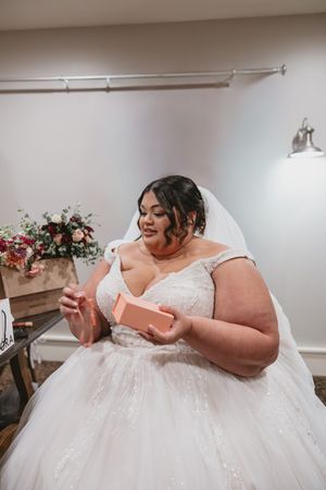 A close-up shot of hands holding wedding cards in an indoor setting.