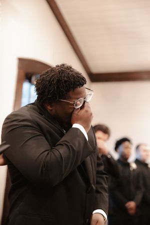 An emotional moment during a formal event in an indoor venue with wooden beams.