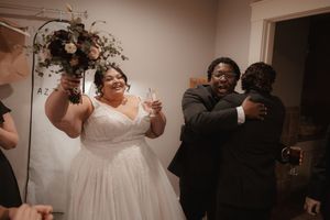 An intimate indoor wedding moment captured with warm lighting and floral decorations.