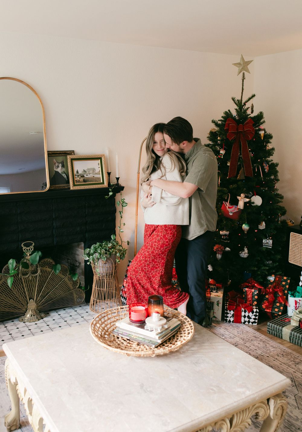 Festive holiday scene with a decorated Christmas tree, presents, and a couple in a bright living room.