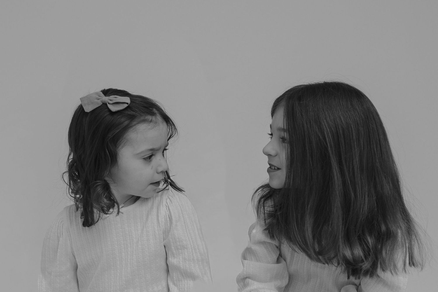 A black and white photograph shows two people in profile having an intimate conversation together.