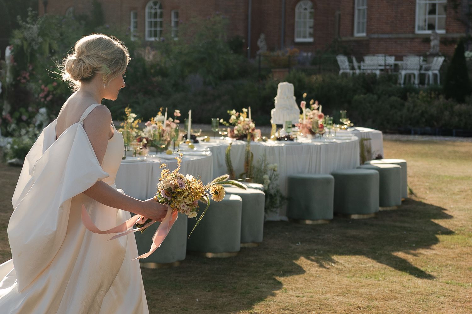 Wedding guests enjoy refreshments and conversation at an elegant outdoor reception with floral arrangements.
