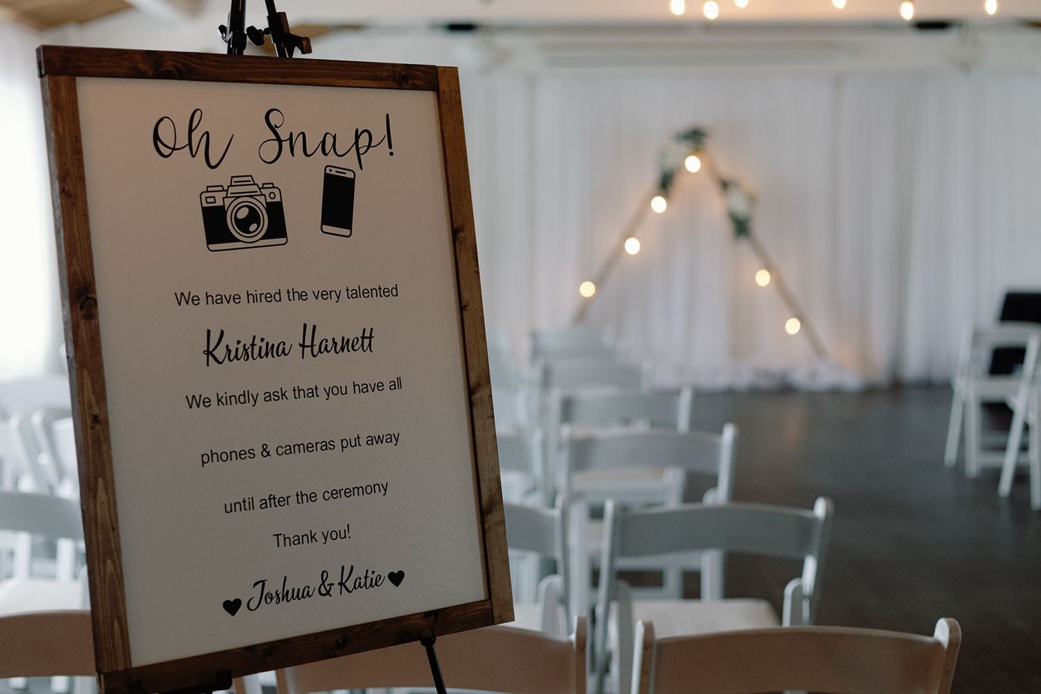 An elegant unplugged wedding ceremony sign on an easel requesting guests put away phones and cameras.