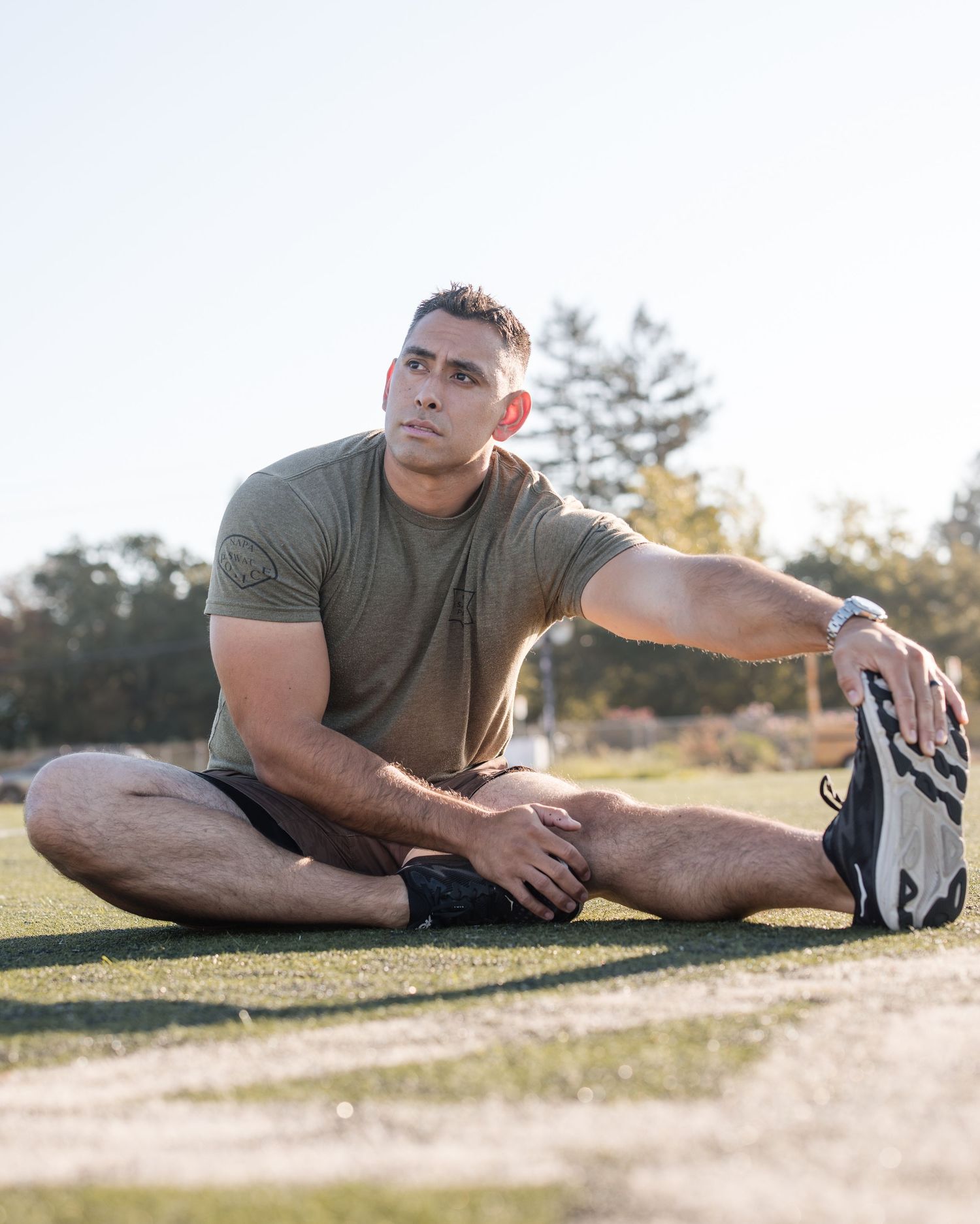 Person in athletic wear performing stretching exercises outdoors.