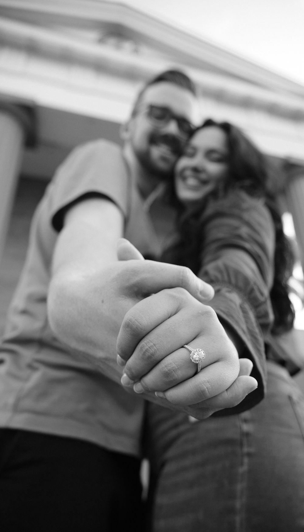 A series of black and white photos showing close-up shots of hands displaying an engagement ring.