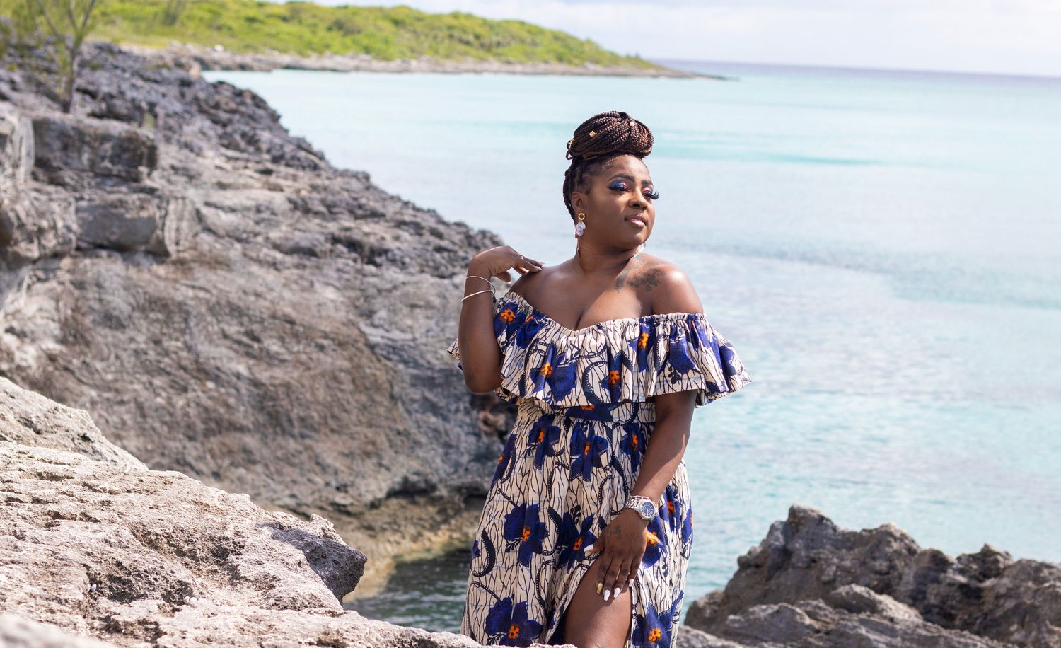 Scenic beach photography with rocky coastline and turquoise waters in the background.