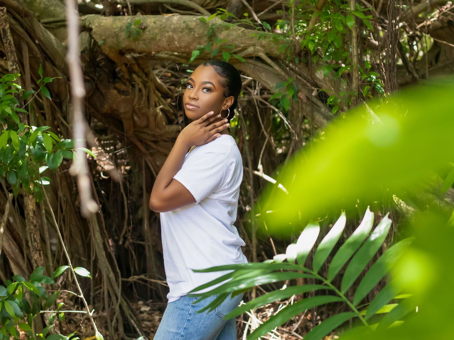 Natural outdoor portraits captured through lush green foliage and tree branches.